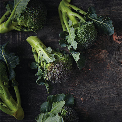 Raw broccoli on wooden table